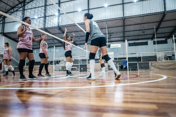 Female volleyball players playing a volleyball match on the sports court