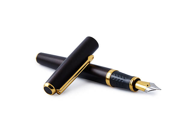 Elegant gold fountain pen isolated with clipping path Elegant gold plated business fountain pen isolated on white with cap. Clipping path included. Copy space. fountain pen photos stock pictures, royalty-free photos & images