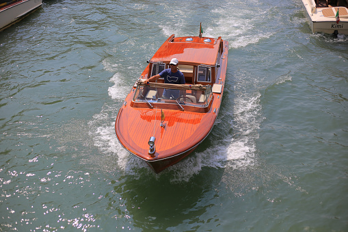 Venice, Italy - 21 July, 2019:  Brown classic taxi motor boat in Venice, front view
