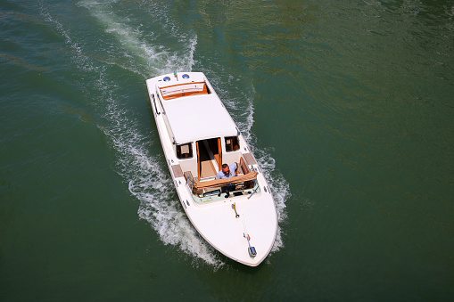 Venice, Italy - 21 July, 2019:  White excursion motor boat in Venice, top view