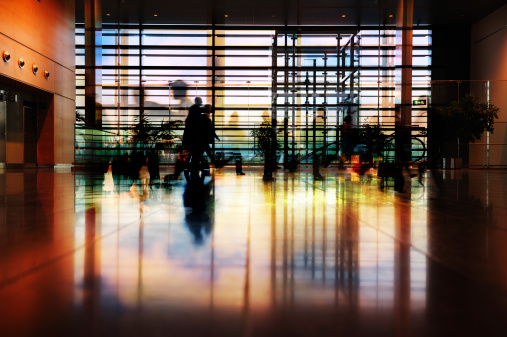 Long time exposure of travellers in modern style terminal building.
