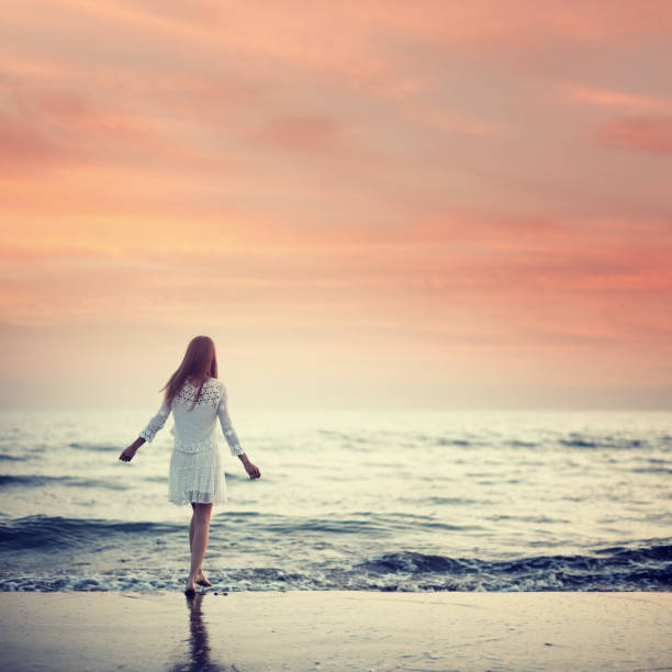 girl walking on the beach at sunset. Not oversized, digitally stitched from 2 images.