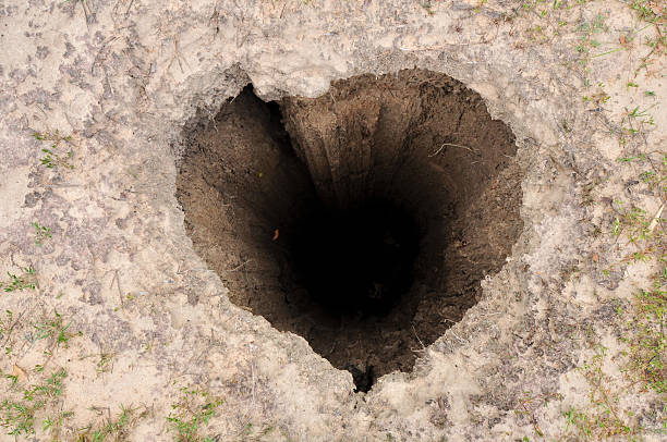 Heart shaped deep hole in the ground stock photo