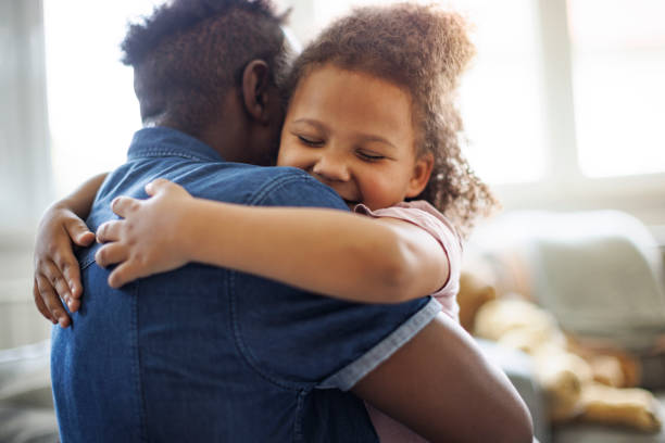 istock Father and daughter embracing at home 1570173661