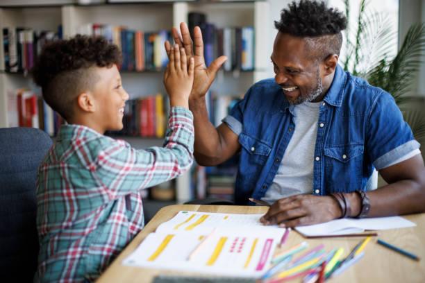 Padre che aiuta il figlio con i compiti - foto stock