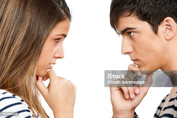 Teen Coupe Looking At Each Other Wondering Stock Photo - Download Image Now - Face To Face, Couple - Relationship, Profile View