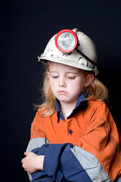 Young girl in coal miner hard hat and safety clothing stock photo