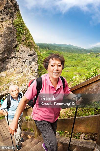 Senior Pareja Asiática Excursionismo En La Montaña Foto de stock y más banco de imágenes de Tercera edad - Tercera edad, Ejercicio físico, Etnias asiáticas e indias