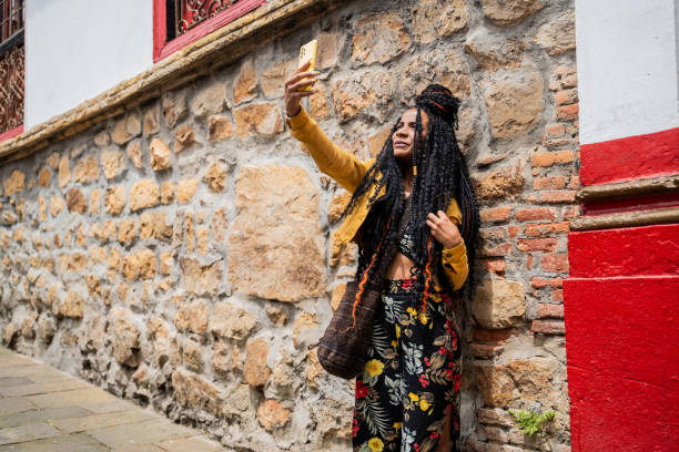 Mid adult woman taking a selfie using mobile phone outdoors