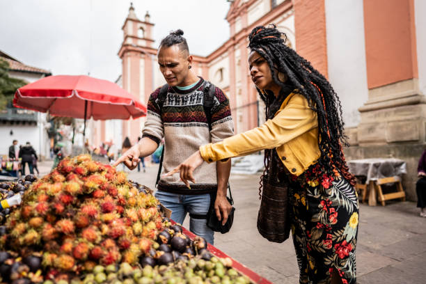 Friends buying fruits in a street market in the in historic district of Bogota, Colombia
