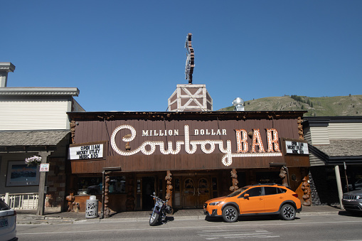 Cars and motorcycles outside Million Dollar Cowboy Bar on North Cache Street at Jackson Town Square (Jackson Hole) in Teton County, Wyoming