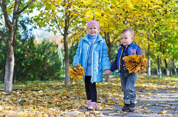 istock Young Children with Autumn Leaves 157028255
