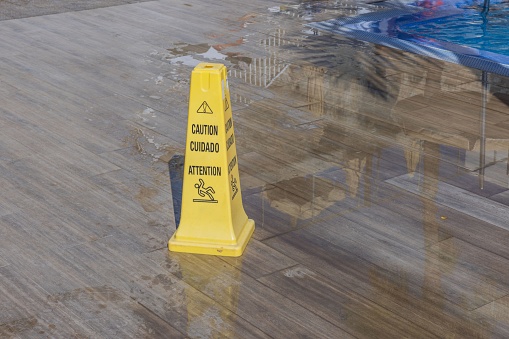 Close-up view of yellow wet floor attention sign. Gran Canaria, Spain.
