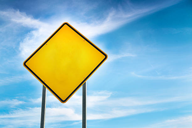 Blank, Yellow Road Warning Sign and blue sky behind