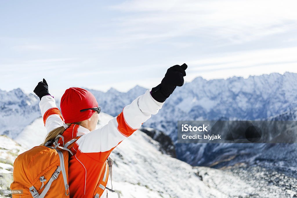 Femme vient compléter l'ascension sur les montagnes d'hiver - Photo de Atteindre libre de droits