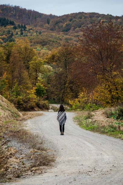 istock Beautiful female model within the autumn colors forest 1570315724