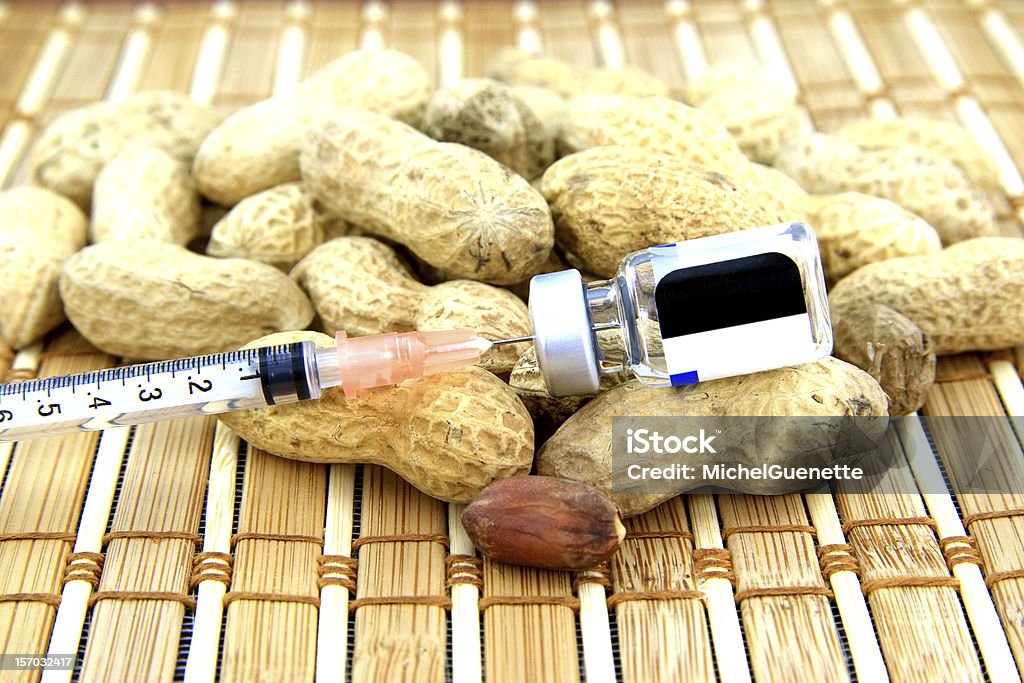 Peanuts with a syringe and medication Many peanuts with a syringe in a bottle of medication for allergy Allergy Stock Photo