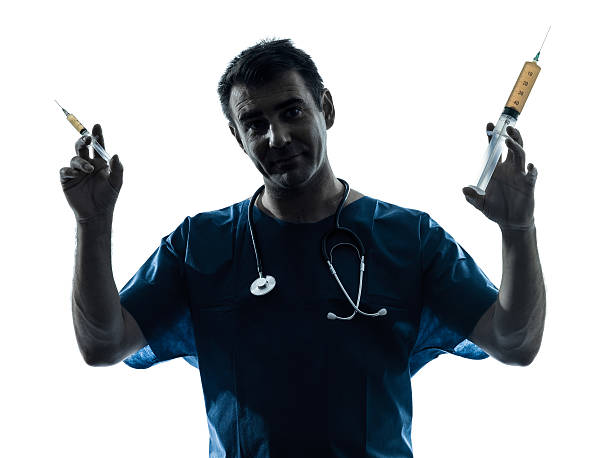 istock doctor man holding hypodermic syringe silhouette portrait 157032634