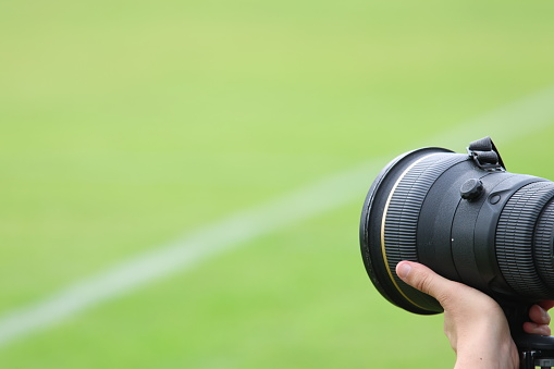 The telephoto lens of a camera used in sporting events.
