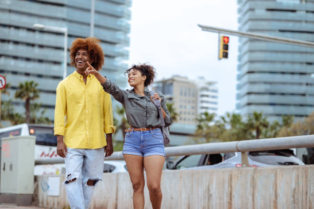 istock Young, multiracial couple cheerfully talking, while walking through Barcelona 1570336768