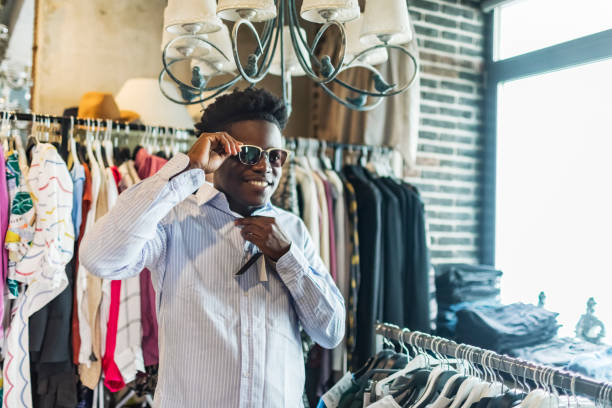 istock Young adult Black man choosing sunglasses 1570369897