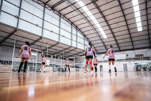 Female volleyball players playing a volleyball match on the sports court