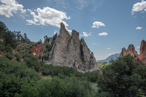 Dramatic clouds and Massive red sandstone rock formations at entry to the Garden of the Gods in Colorado Springs, Colorado in western USA of North America. Pikes Peak in the background.