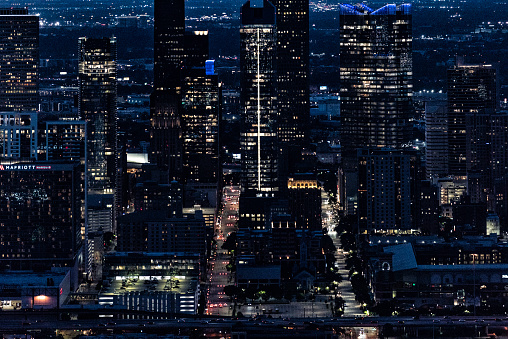 The illuminated streets and buildings of downtown Houston, Texas on an early spring evening just after sunset shot from an altitude of about 800 feet directly over the city.