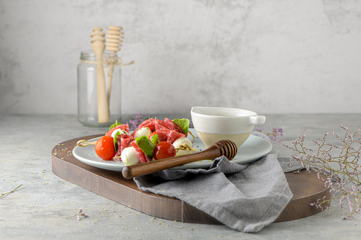 Italian style appetizer, antipasto skewer or caprese on a stick with basil, salami, mozarella and tomatoes.