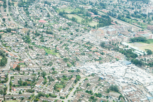 African cityscape with view of housing area, streets and buildings in Nairobi area. Shed market area is shown along with industrial area. Multi-story buildings along with  residential houses are in the view. This is the view from above the area from a plane window.