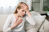 Woman holding hand on chest and having panic attack