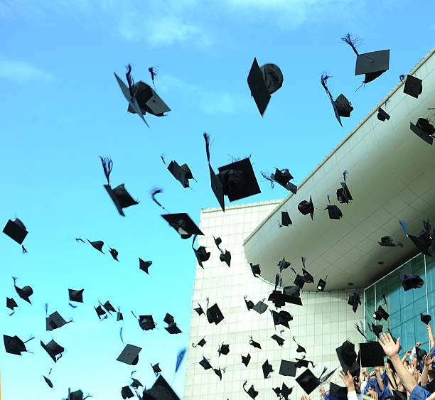 istock Graduation caps flying through the air 157045208