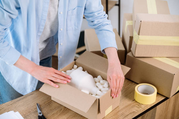 istock Woman preparing a parcel for delivery for client 1570453500