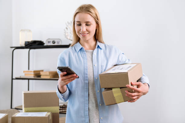 istock Ecommerce business owner holding parcel, checking delivery information in online app 1570455179
