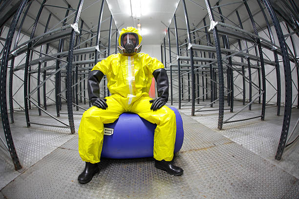 worker in safety - protective uniform,sitting on blue barrel