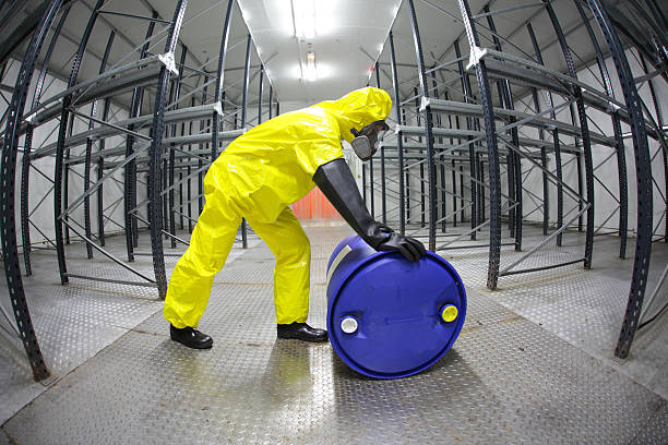 istock technician,rolling the barrel with toxic substance in empty warehouse 157045597