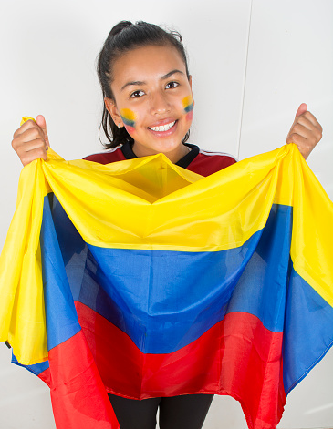 Happy young girl holding an Colombian flag.