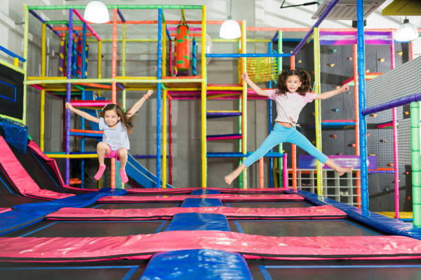 istock Happy children laughing while playing and jumping on the trampoline 1570523360