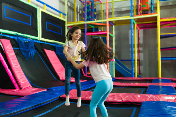istock Cheerful kids laughing while playing in the trampoline 1570535578