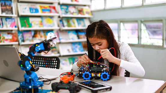 Kid female teen children enjoy Machine Learning Robot  motion is Moving Under Control robot in technology class, stem education robot motion  for digital automation software for artificial intelligence