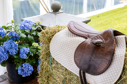 Western themed decor with saddle, hay and flowers.