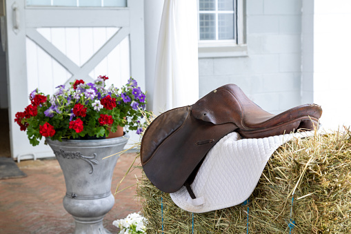 Western themed decor with saddle, hay and flowers.