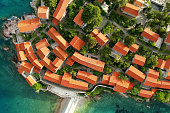 Amazing sunset aerial top drone view of Sveti Stefan hotel island with historical town. Top down view of picturesque little island in Adriatic Sea located in Montenegro.