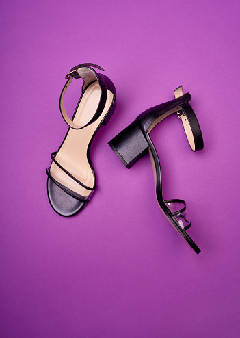 Glamorous open-toe women's shoes with block heels, clear vamps, ankle straps and beige insoles, isolated on a purple background. Fashion photography