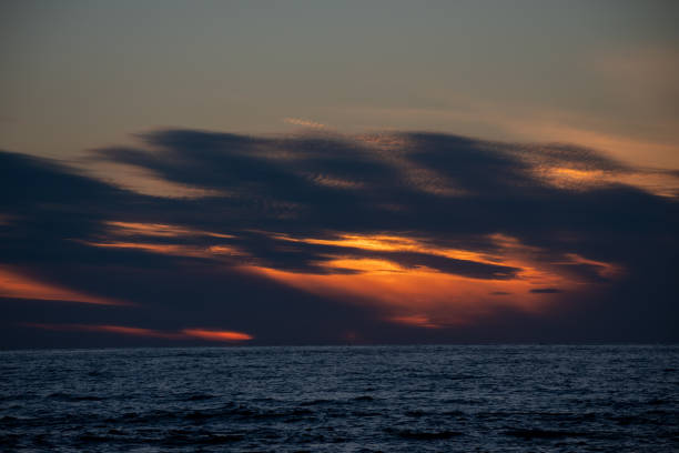 istock Beautiful sunset clouds on a quiet sea 1570589081