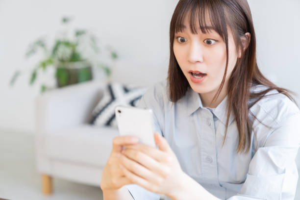 attractive Asian woman using a smart phone,surprised