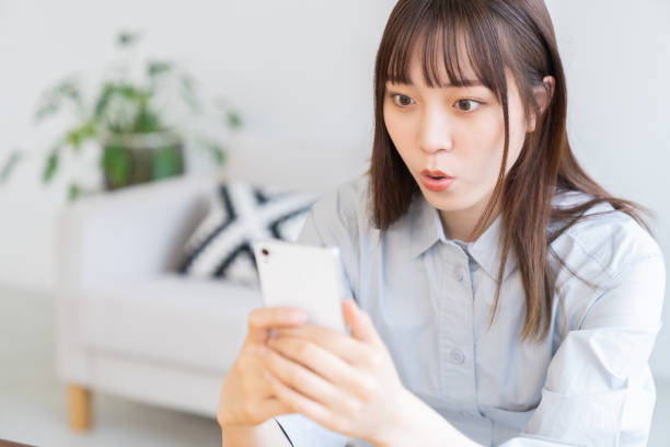 istock attractive Asian woman using a smart phone,surprised 1570602477