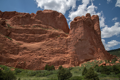 Dramatic clouds and Massive red sandstone rock formations at entry to the Garden of the Gods in Colorado Springs, Colorado in western USA of North America. Pikes Peak in the background.