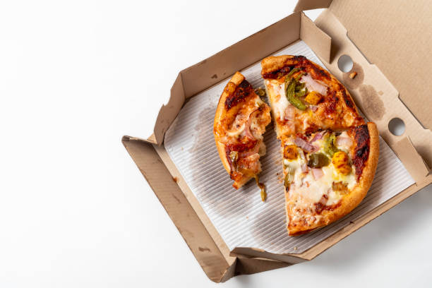 istock Leftover pizza in an open cardboard pizza box isolated on white background. Top view 1570635367