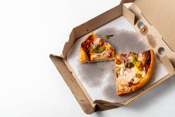 istock Leftover pizza in an open cardboard pizza box isolated on white background. Top view 1570636418